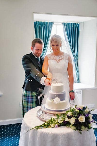Carly and Andy cutting the wedding cake at New Lanark Mill Hotel