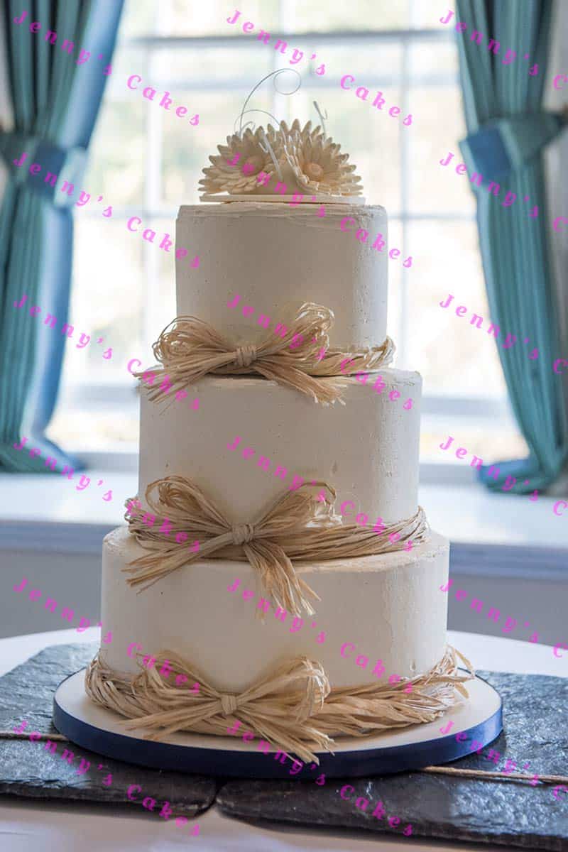 Wedding cake in smooth butter-cream with raffia bows